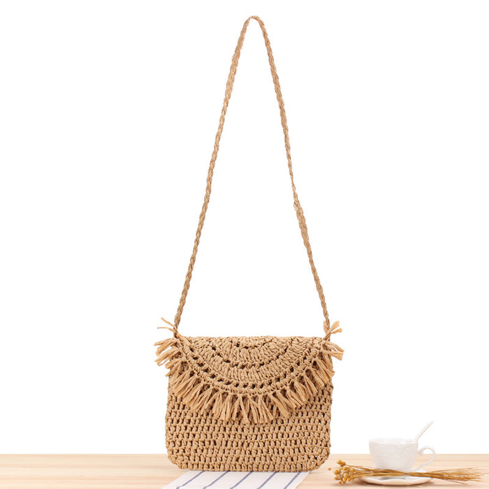 A Hand-Made Tassel Beach Knitting Bag by Beachy Cover Ups with tassels on a table.
