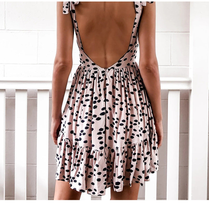 The back view of a Beachy Cover Ups beach goddess wearing a pink and black Backless Sling Wave Polka Beach Dress.