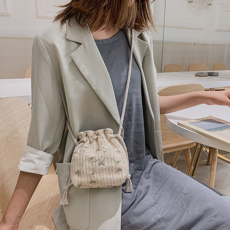 A woman holding a Floral Lace Vacation Beach Bag by Beachy Cover Ups at a table.