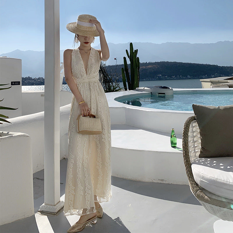 A woman in a High Waist Open Back Floral Apricot Beach Dress by Beachy Cover Ups standing next to a pool.