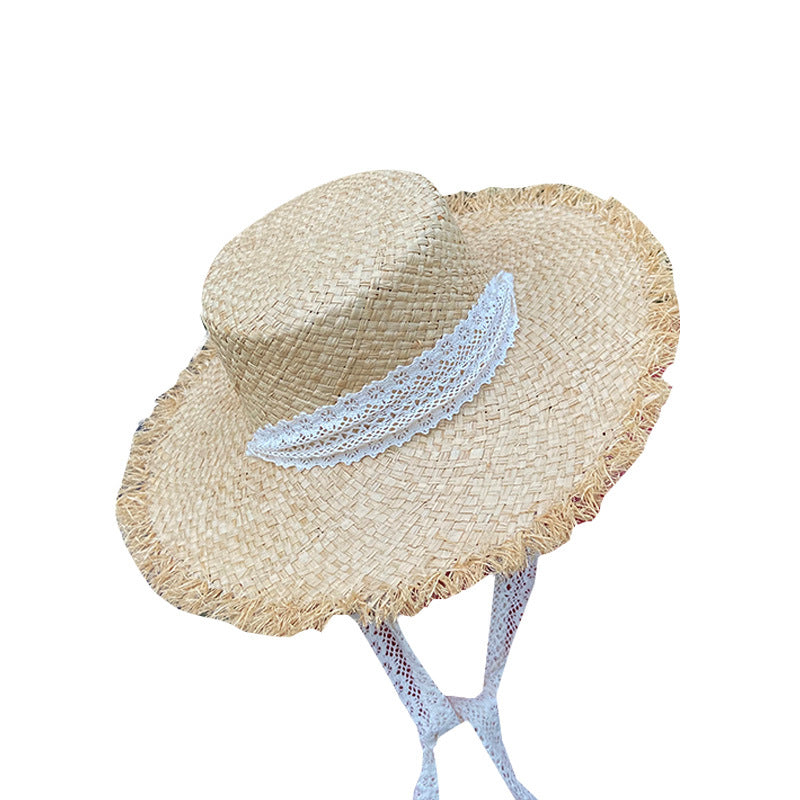 A Fringed Seaside Beach Lace Sun Hat by Beachy Cover Ups with a white ribbon.