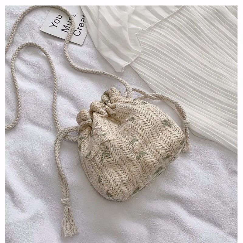 A white lace shirt by Beachy Cover Ups and a Floral Lace Vacation Beach Bag create an urban simplicity on a white bed.