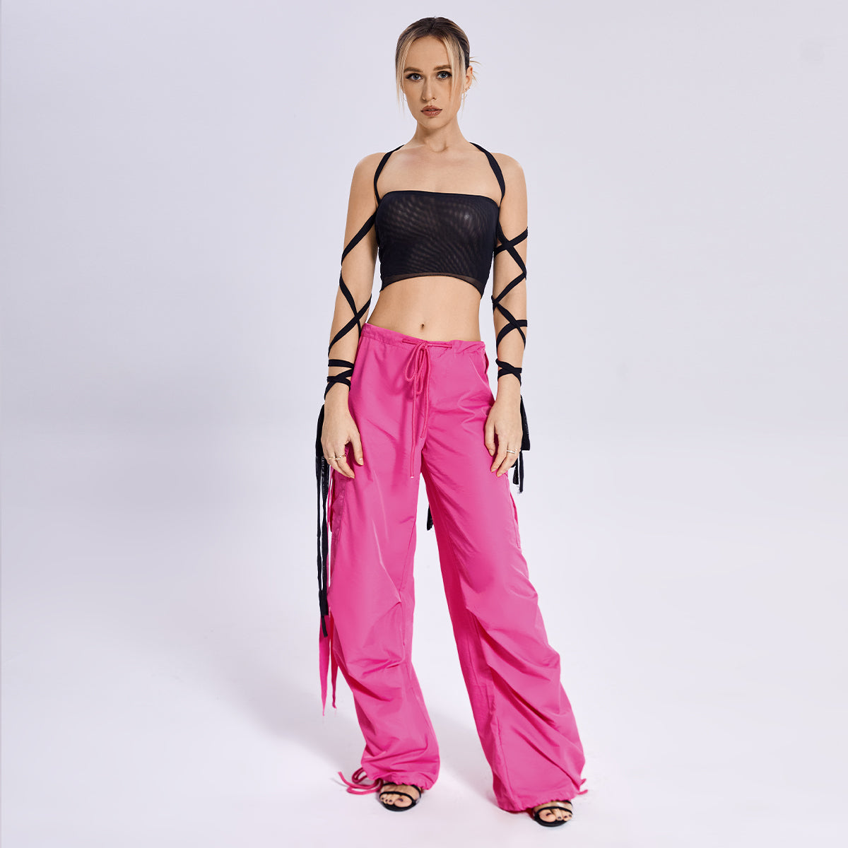 The model is wearing a fashion-forward Beachy Cover Ups Arm Ribbon Straps Black Top with wide leg pants.