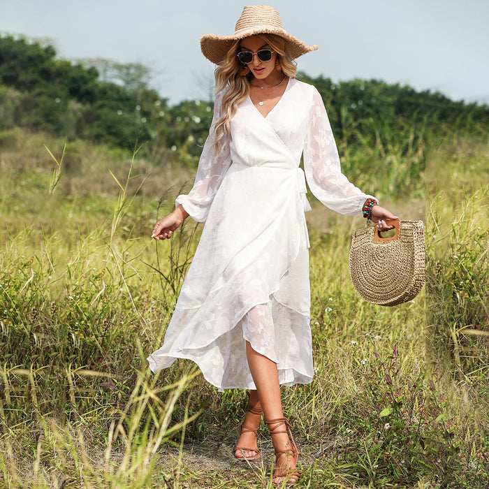 A woman in a Long Sleeve V Neck Beach Dress by Beachy Cover Ups and straw hat walking through a field.